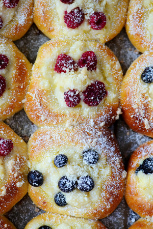 Polish sweet yeast Butter buns with vanilla pudding and berries and streusel sprinkled with powdered sugar .style hugge .top veiw.selective focusの写真素材