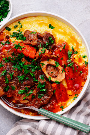 Stewed in osso bucco sauce with vegetables and cheese polenta in a bowl. top view. style hugge. Selective focusの写真素材