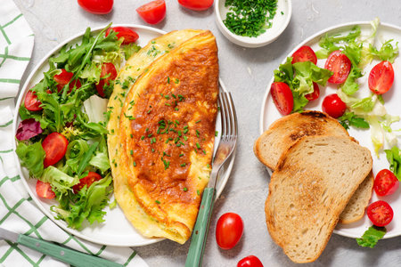 Cheese omelette with fresh green salad and toast on a plate. top veiw.selective focusの写真素材