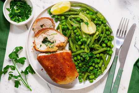 Chicken Kiev with green vegetables, peas and green beans., traditional Ukrainian dish.top veiw....