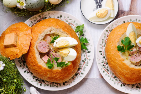 Traditional Polish Easter soup zurek served in a loaf of bread, smoked meats and egg.top veiw.selective focusの写真素材