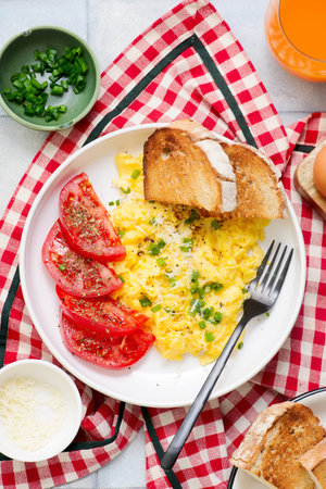Scrambled eggs, tomatoes and toast for breakfast.top veiw. selective focus