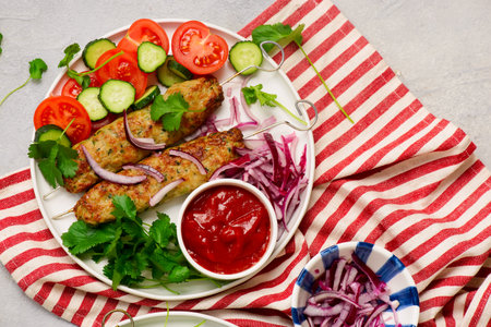 Chicken Lula Kebab with fresh vegetables and hot sauce on a platter.top veiw .selective focusの写真素材