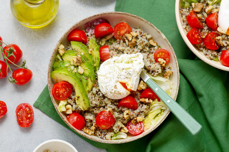 Gluten Free Bowl with Quinoa, Avocado, Cherry Tomatoes, Poached Egg and Walnuts for breakfast. selective focus. top veiwの写真素材