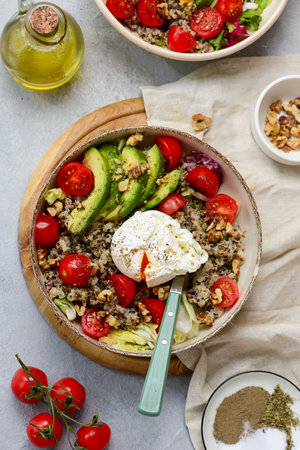 Gluten Free Bowl with Quinoa, Avocado, Cherry Tomatoes, Poached Egg and Walnuts for breakfast. selective focus. top veiwの写真素材