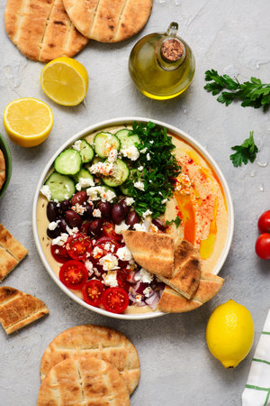 Greek style hummus bowl with vegetables, olives, feta and pita. top view..selective focusの写真素材