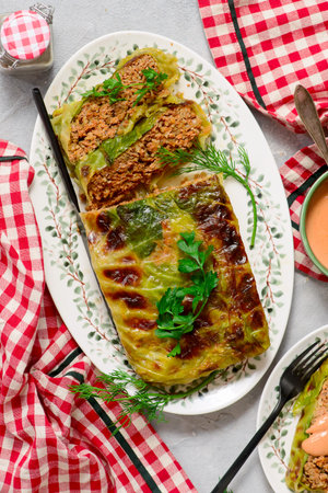 Baked cabbage roll with minced meat and sour cream and tomato sauces, top veiw. selective focus