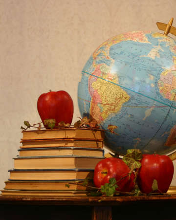 Still life of books, apples, and globeの写真素材