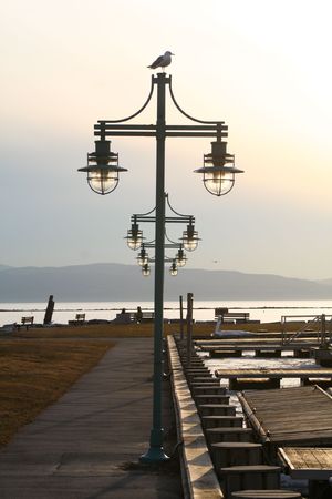 a centered row of lamp posts leading out to the watersideの写真素材