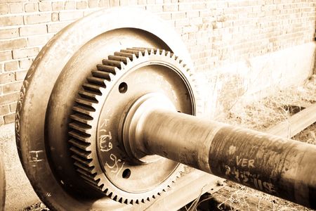 One end of a rusty train axle by a brick wallの写真素材