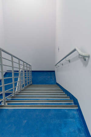 Stairway in office building with metal handles and blue carpetの写真素材