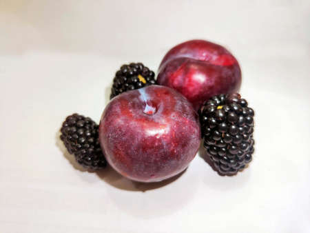 Red plum with Black blueberry in white backgroundの写真素材