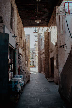 An old alley with goods on the sides covered with cloth and a bamboo ceiling with light bulbs in Souq Waqif in Qatarの写真素材