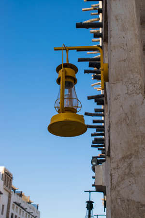 Old yellow light bulb hanging on the wall in Souq Waqif, Qatarの写真素材