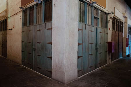 A wide view of old shops with wooden doors and metal hinges in Souq Waqif, Qatarの写真素材