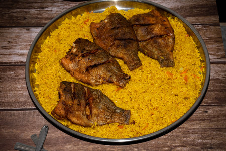 Fried fish with rice in a plate on a wooden table.の写真素材