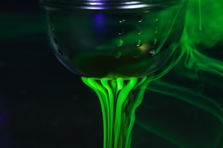 A tea ball with fluorescein in water.  Fluorescein is a green, fluorescent coloring agent for water.