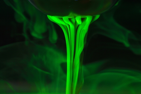 A tea ball with fluorescein in water.  Fluorescein is a green, fluorescent coloring agent for water.の写真素材