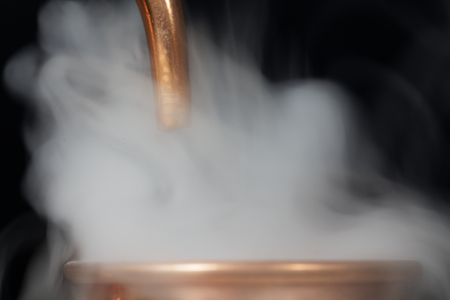 A copper pipe of a distillery with steam.の写真素材