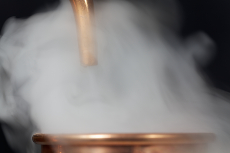 A copper pipe of a distillery with steam.