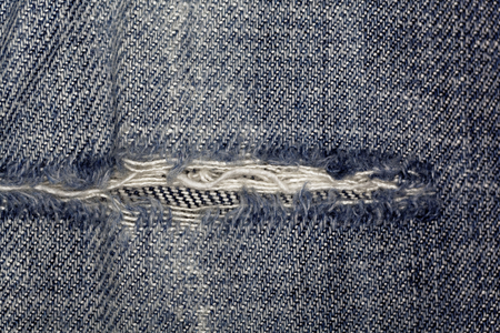 Macro photo of jeans fabric with fissure.