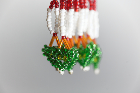 Macro photo of small beads with different colors on a string in form of a heart.の写真素材