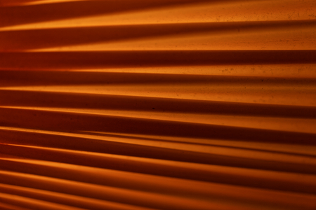 Macro of folded orange textile with background illumination.の写真素材