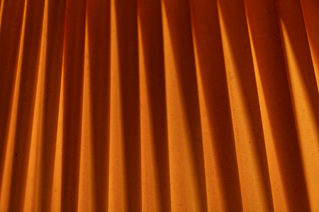 Macro of folded orange textile with background illumination.の写真素材