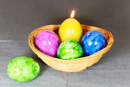 Different colored Easter eggs with a candle.の写真素材