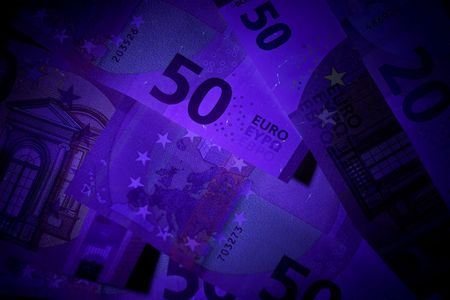 Banknotes in the beam of an UV flash light.の写真素材
