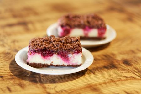 A chocolate cheese cake on a white plate with a wooden background.の写真素材