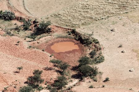 A small red lake surrounded by fields and bushes in Northern Ethiopia.の写真素材