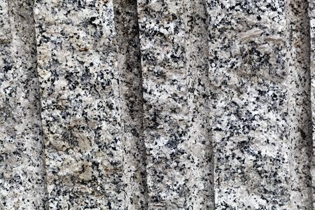 Drilled holes in a granite rock surface from stone mining.