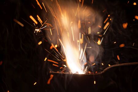 Macro photo of bursting gunpowder with a black background.