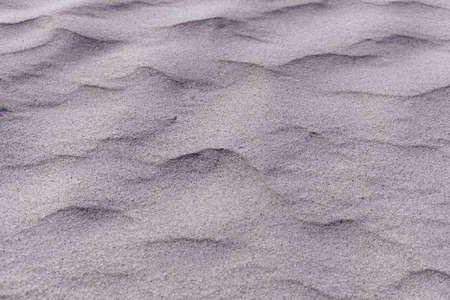 Abstract photo of textures in gray coarse grained sand.