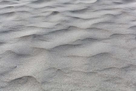 Abstract photo of textures in gray coarse grained sand.の写真素材