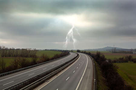 concept photo of an empty highway with a lightning and cloudy sky
