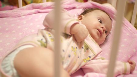 Baby lies in crib.の写真素材