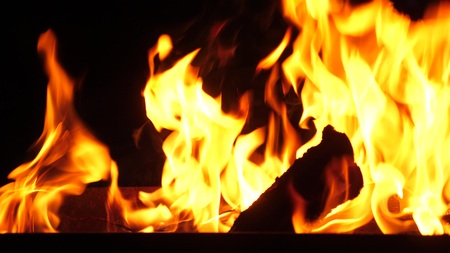 fire burns in the grill at night, close-up