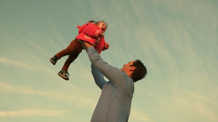 dad toss up a child skyward. father threw the baby to the sky. happy family concept. dad plays with kidの写真素材