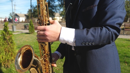 a man playing saxophone jazz music. Saxophonist in dinner jacket play on golden saxophone. Live performance.の写真素材
