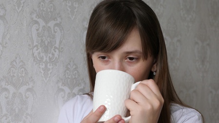 Beautiful young woman dreaming with cup of hot coffee.の写真素材