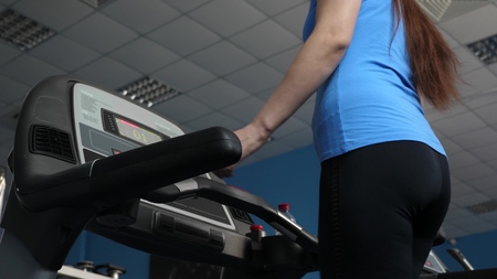 fitness club sexy girl engaged in walking. girl on treadmill goes, cardio load. strengthening...