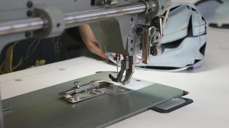 process of sewing leather goods. The needle of the sewing machine in motion. two needles of the...
