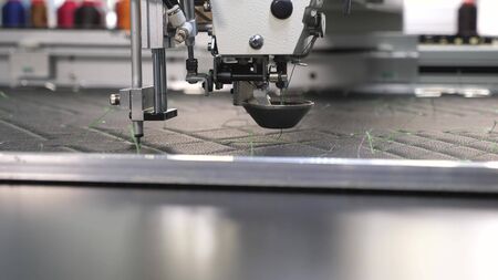 Robotics works in tailoring production line. Robot sewing machine. an automated machine embroidery...