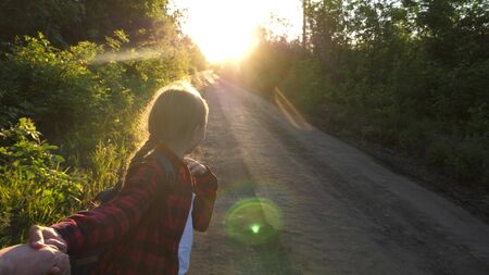 hands in love are traveling. come with me. Hiker Girl with backpack holds man by hand and leads him....
