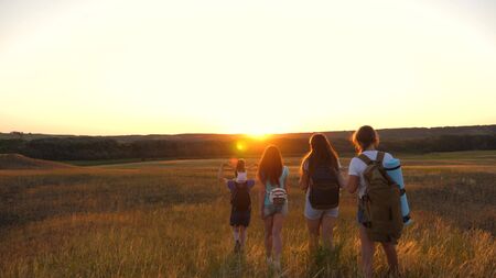 father carries a little daughter on his shoulders, a happy family travels in the park. Family with...
