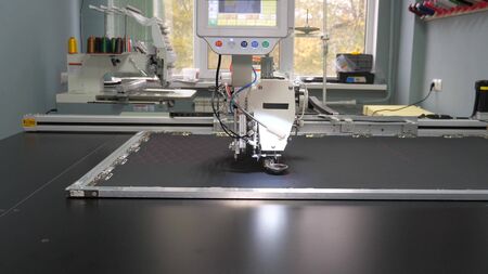 Robotics with cnc works in sewing production line. Robot sewing machine. computer controls sewing machine. automatic sewing machine. Automated machine embroidery.の写真素材