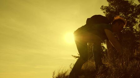 Dad and children tourists with backpacks climb a high mountain. Hiker girls travelers with father are looking for adventure. Sunday dad. Family concept. Camping on vacation with parentの写真素材