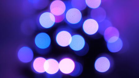beautiful multi-colored bokeh of a Christmas tree in room, decorated with a luminous garland and a star. holiday for children and adults. New Year. Christmas tree, happy holidays. Christmas interior.の写真素材